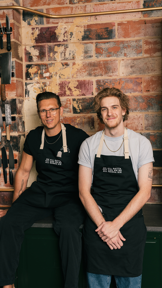 Last Meals Apron with 'WE ALL GOTTA EAT AND WE'RE ALL GONNA DIE' text design.