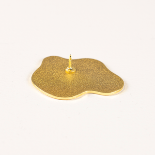 Angled view of gold Sunny Side Up Pin of the Month.